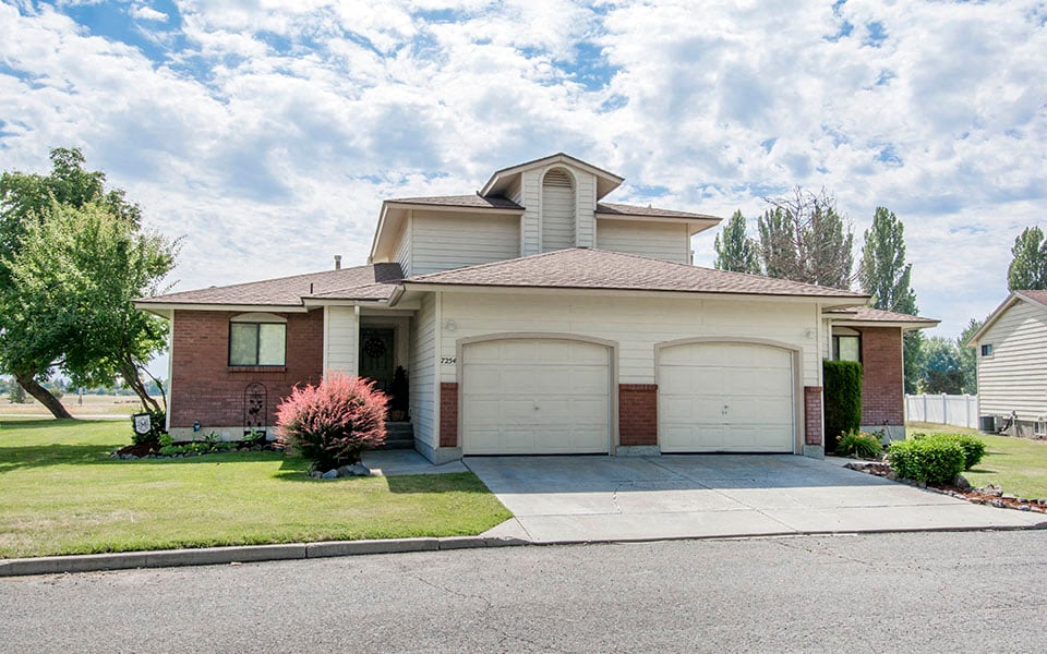 a house with two garage doors and a lawn