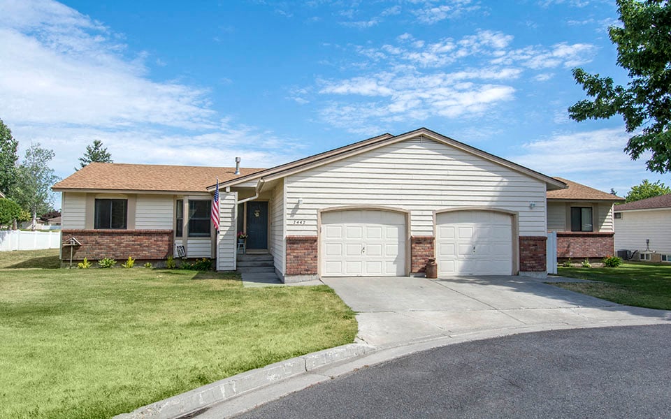 a white house with two garage doors and a driveway