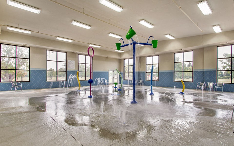 a fenced in multipurpose room with fountains and chairs in it