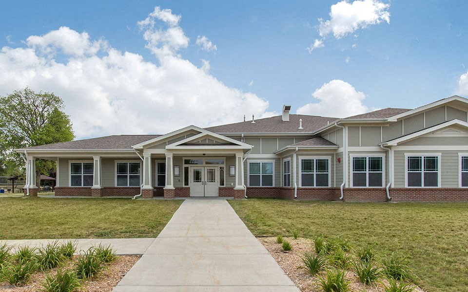 a large house with a lawn and a sidewalk in front of it
