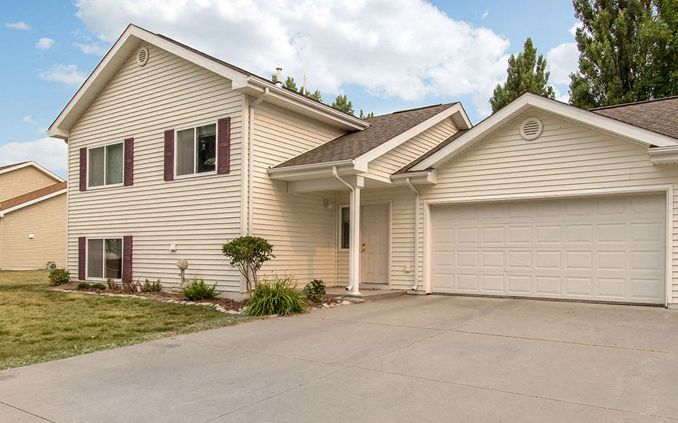 a beige house with a garage and a driveway