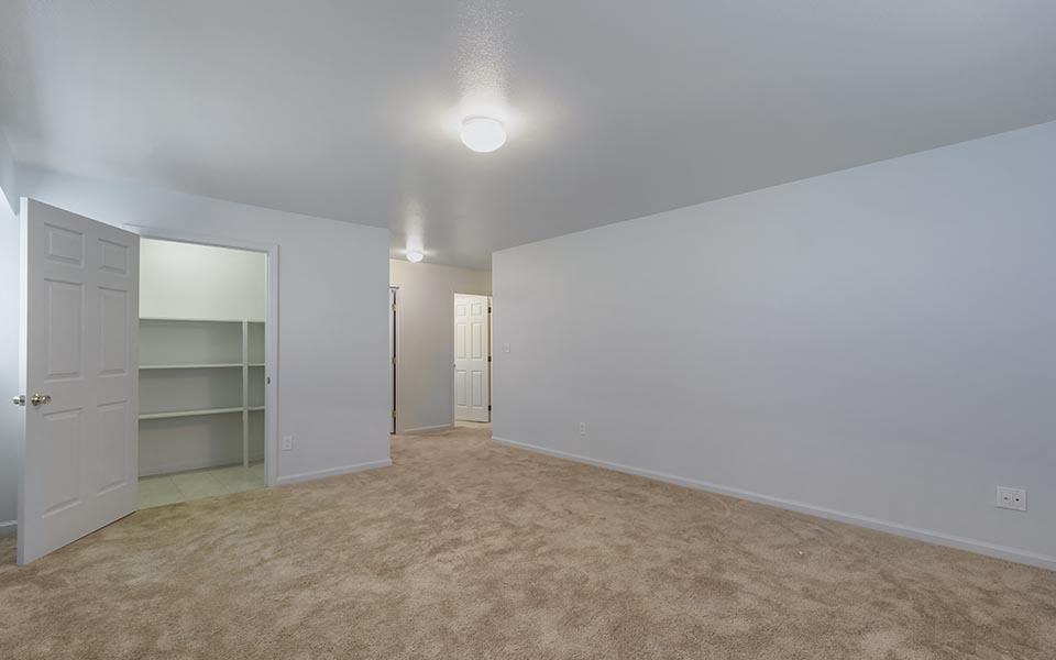 an empty room with a closet and a white door