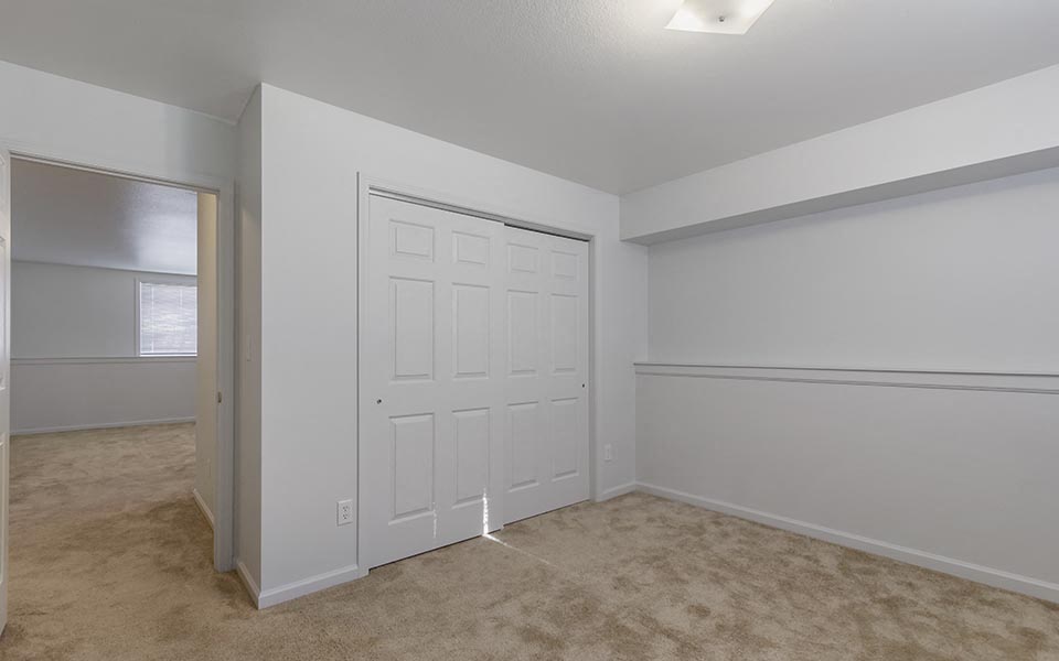 a bedroom with a closet and a white door