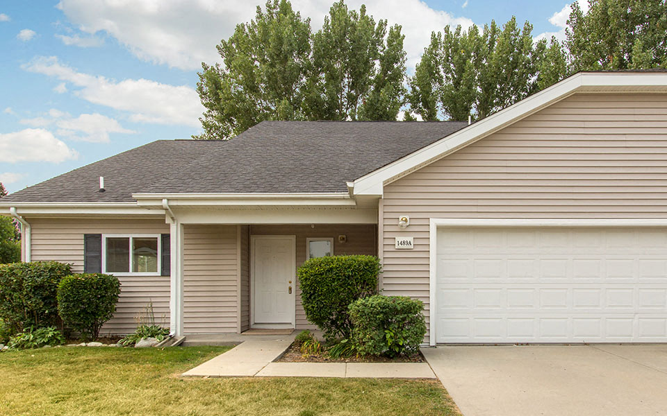 a tan house with a white garage door