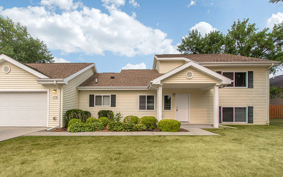 a beige house with a lawn in front of it