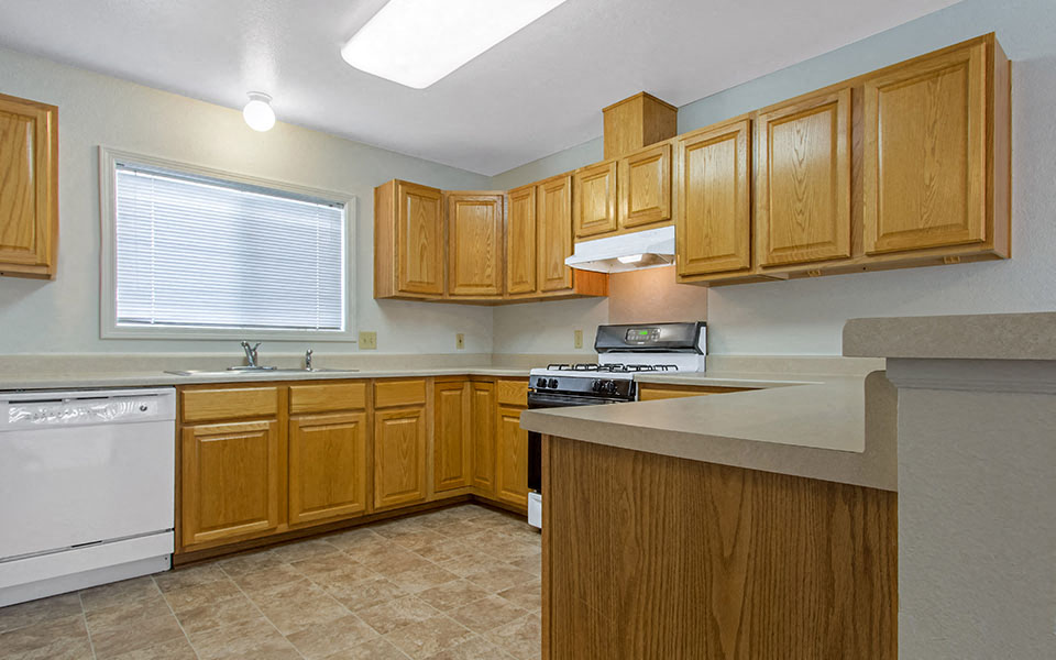 a kitchen with wooden cabinets and a stove and a sink