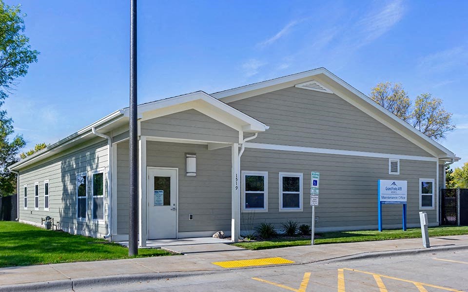 a gray building with a sign in front of it