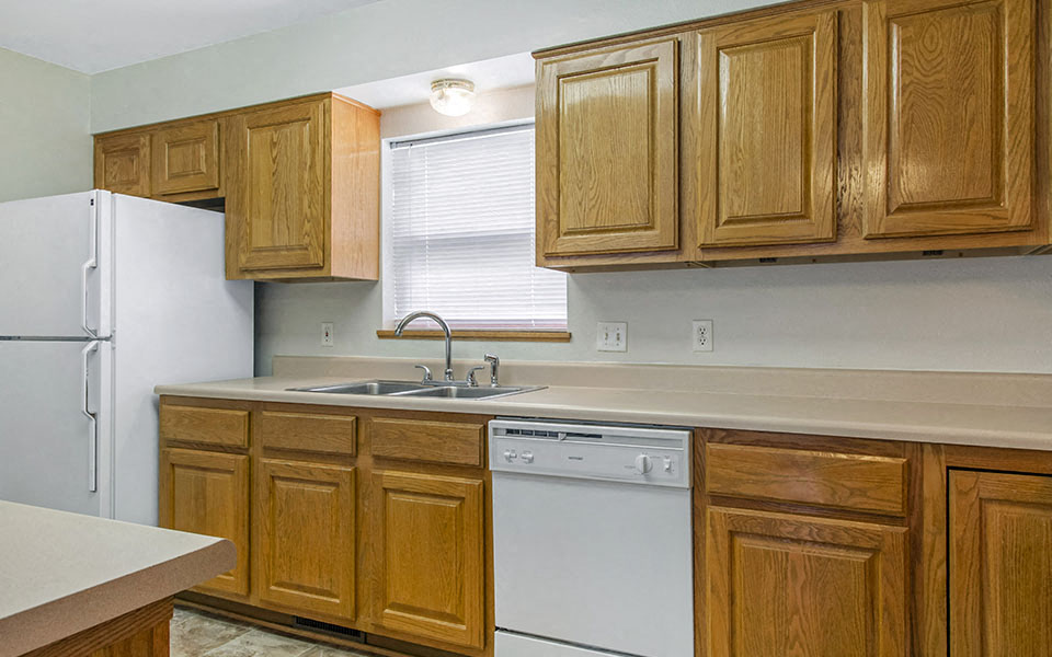 a kitchen with white appliances and wooden cabinets