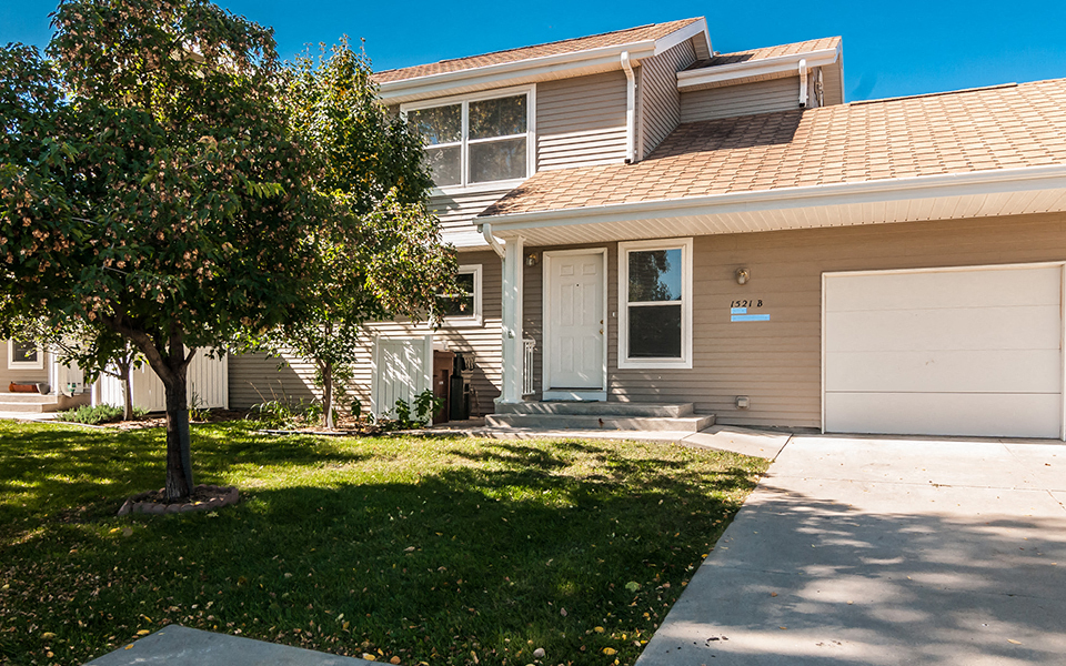 a white house with a tree in the front yard