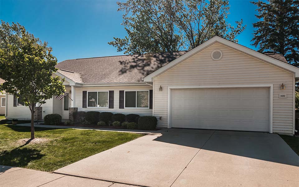 a white house with a driveway and a garage door