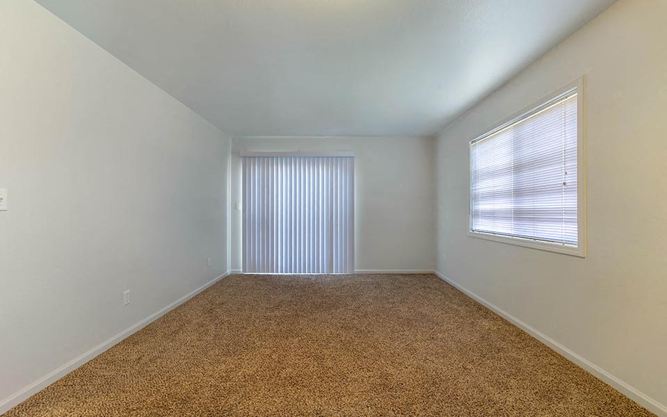 an empty room with a window and white walls