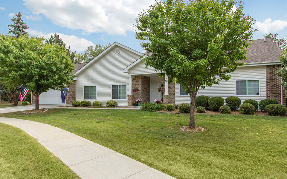 a white house with a lawn and trees in front of it