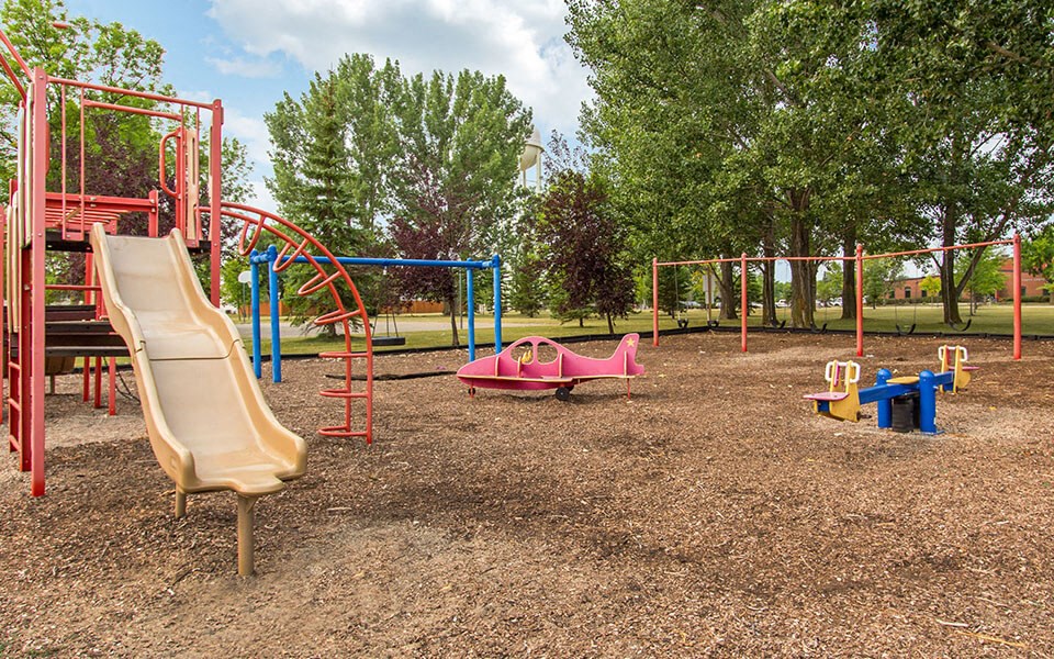 a playground with a slide and other toys in a park