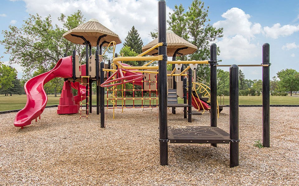 a playground with a pink slide and other playground equipment