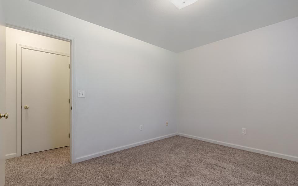 an empty room with a door to a closet