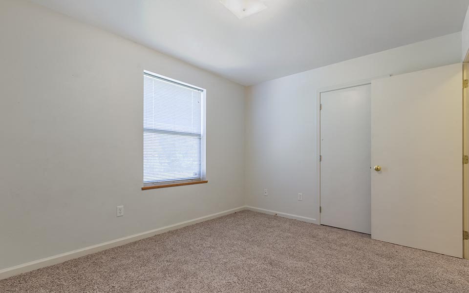 an empty room with a window and a door