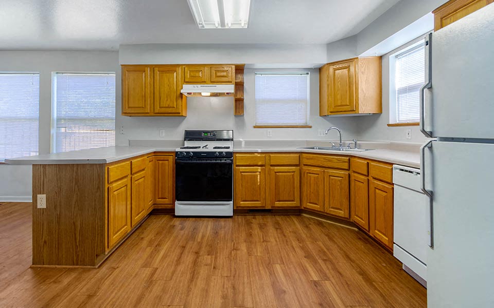 a kitchen with wooden cabinets and a stove and a refrigerator