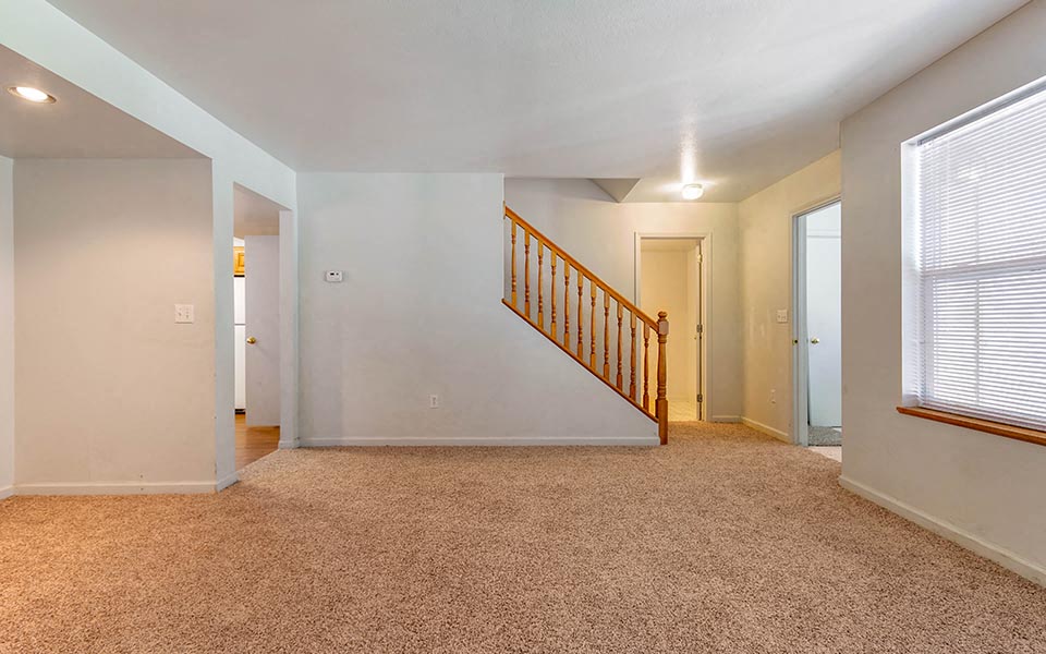 a living room with a staircase and a window
