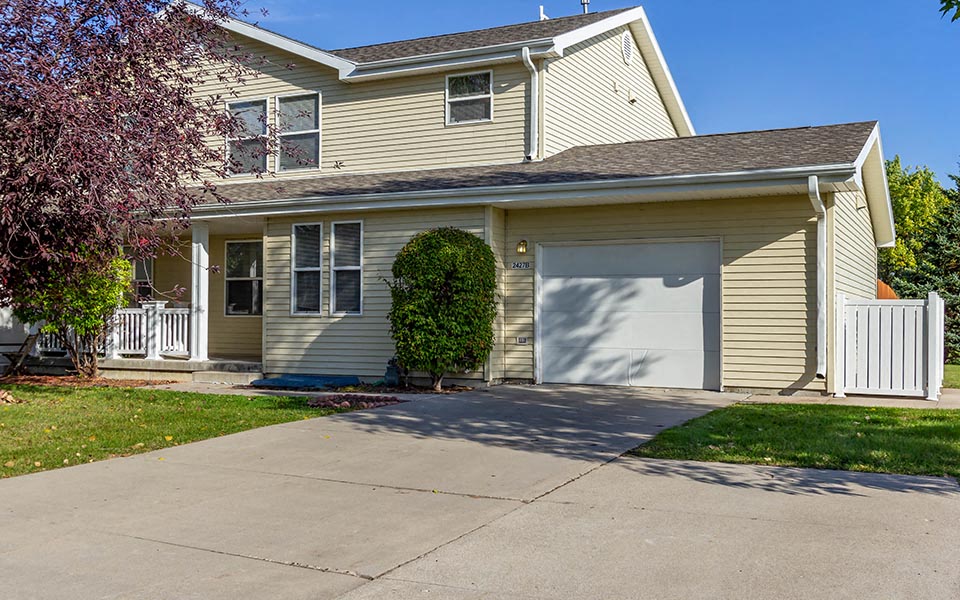 a yellow house with a white garage door