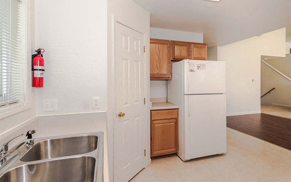 a kitchen with a white refrigerator and a sink