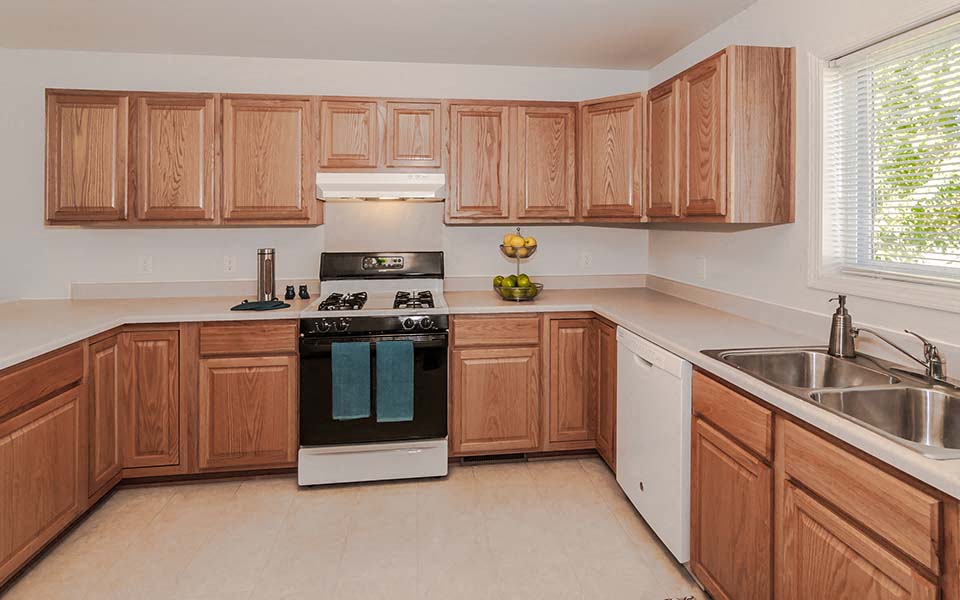 a kitchen with wooden cabinets and a stove and a sink