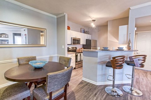 A modern kitchen with a dining table and chairs.