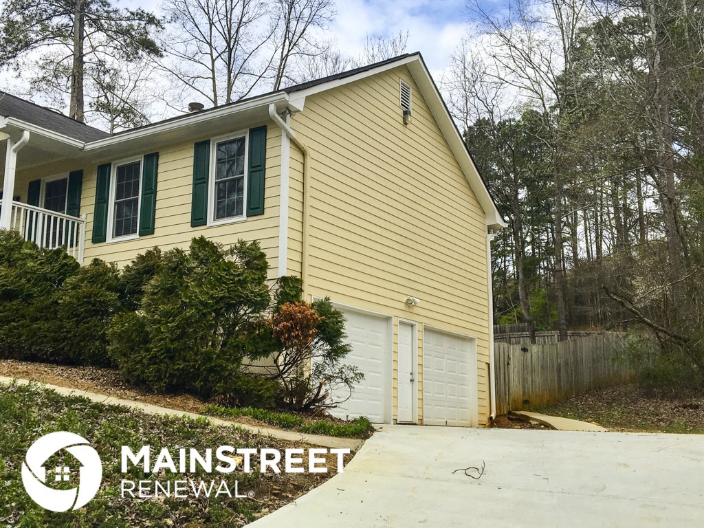 a yellow house with green shutters and a garage door