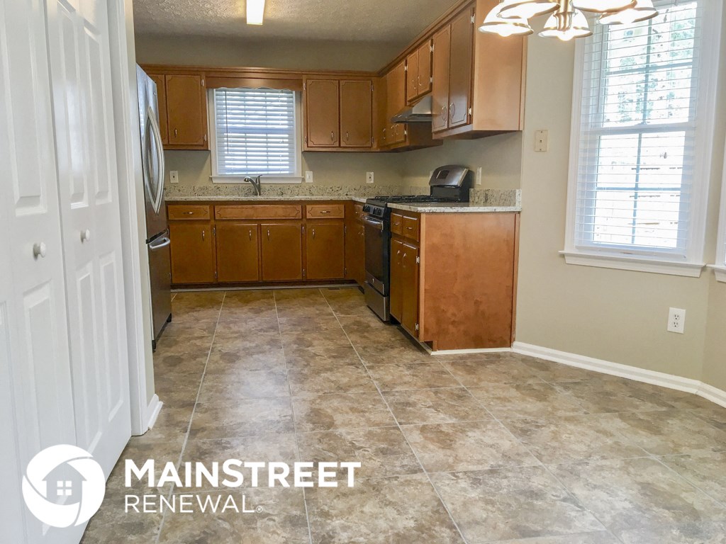 an empty kitchen with wood cabinets and tile flooring