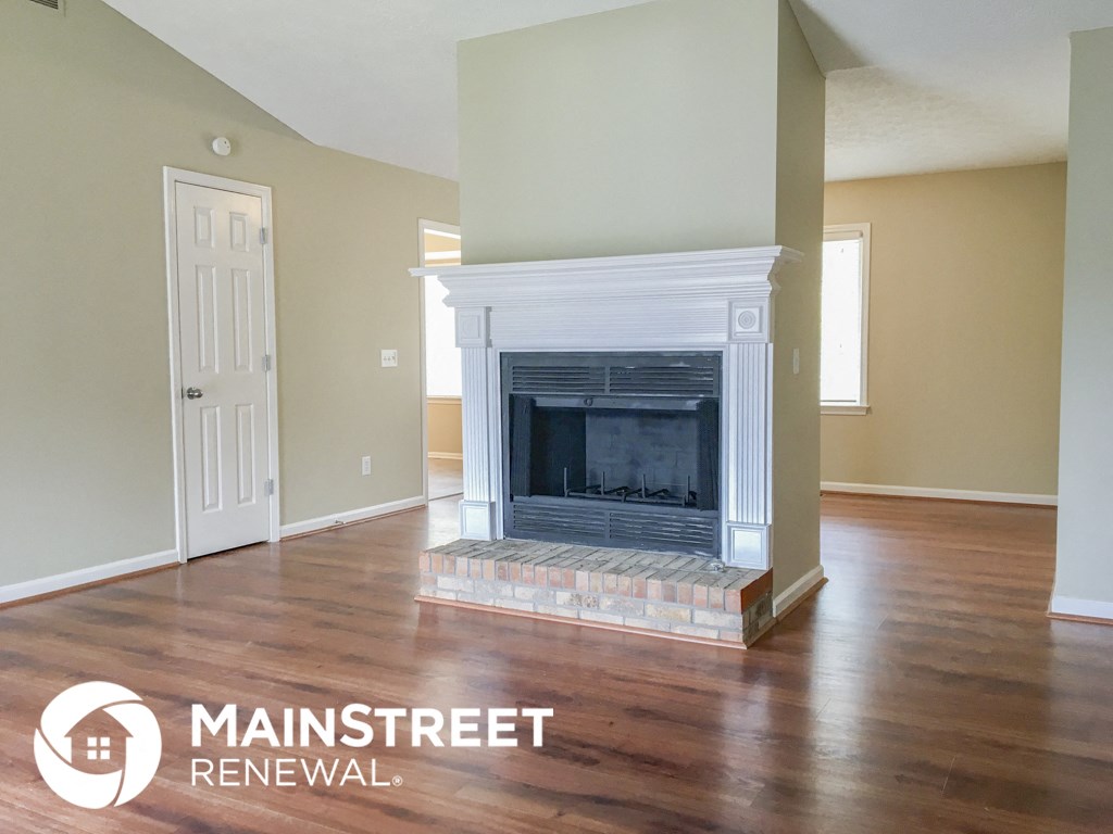 a living room with wood floors and a fireplace