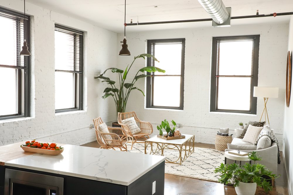 A kitchen with a marble countertop and a dining table with chairs.