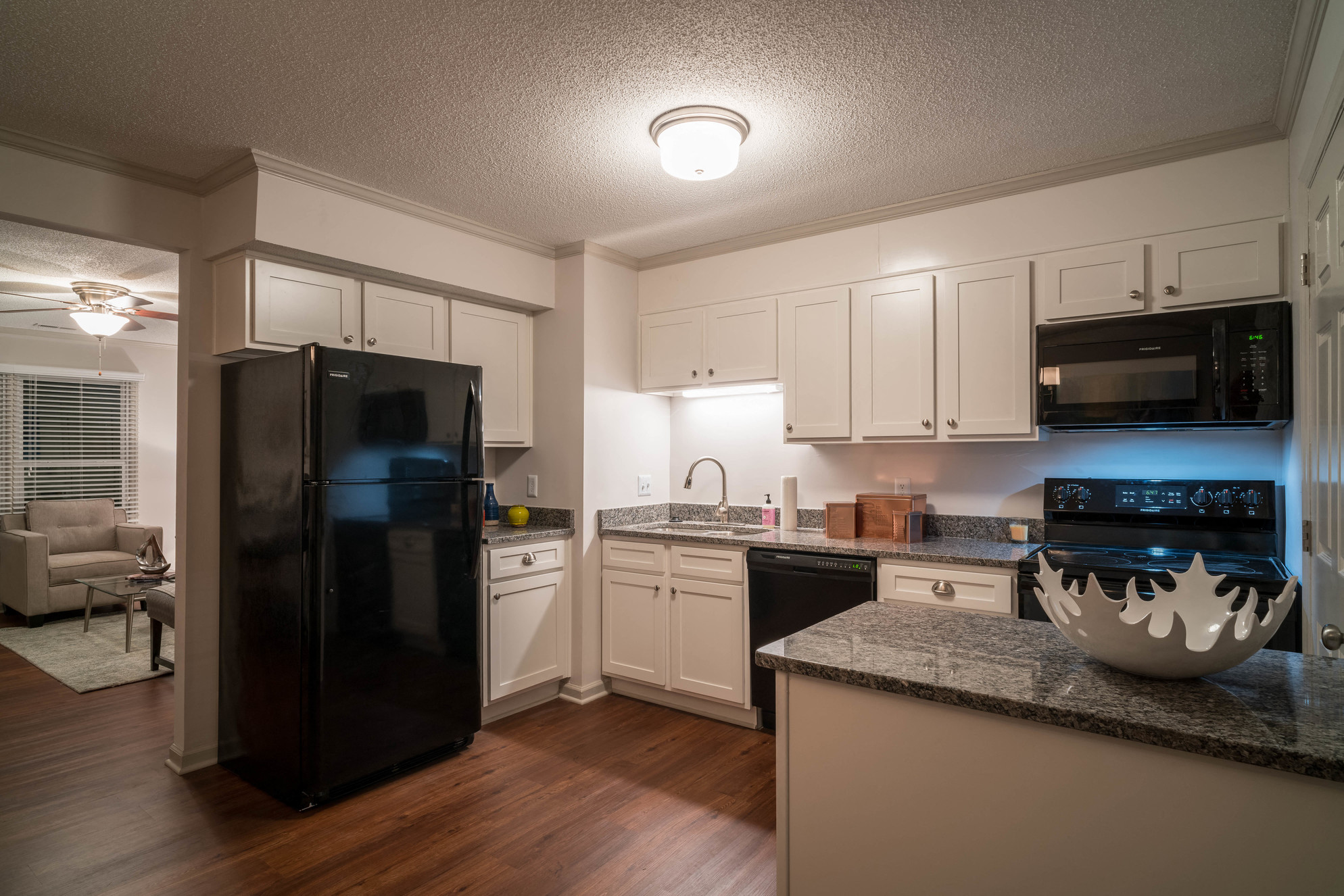 a kitchen with white cabinets and a black refrigerator