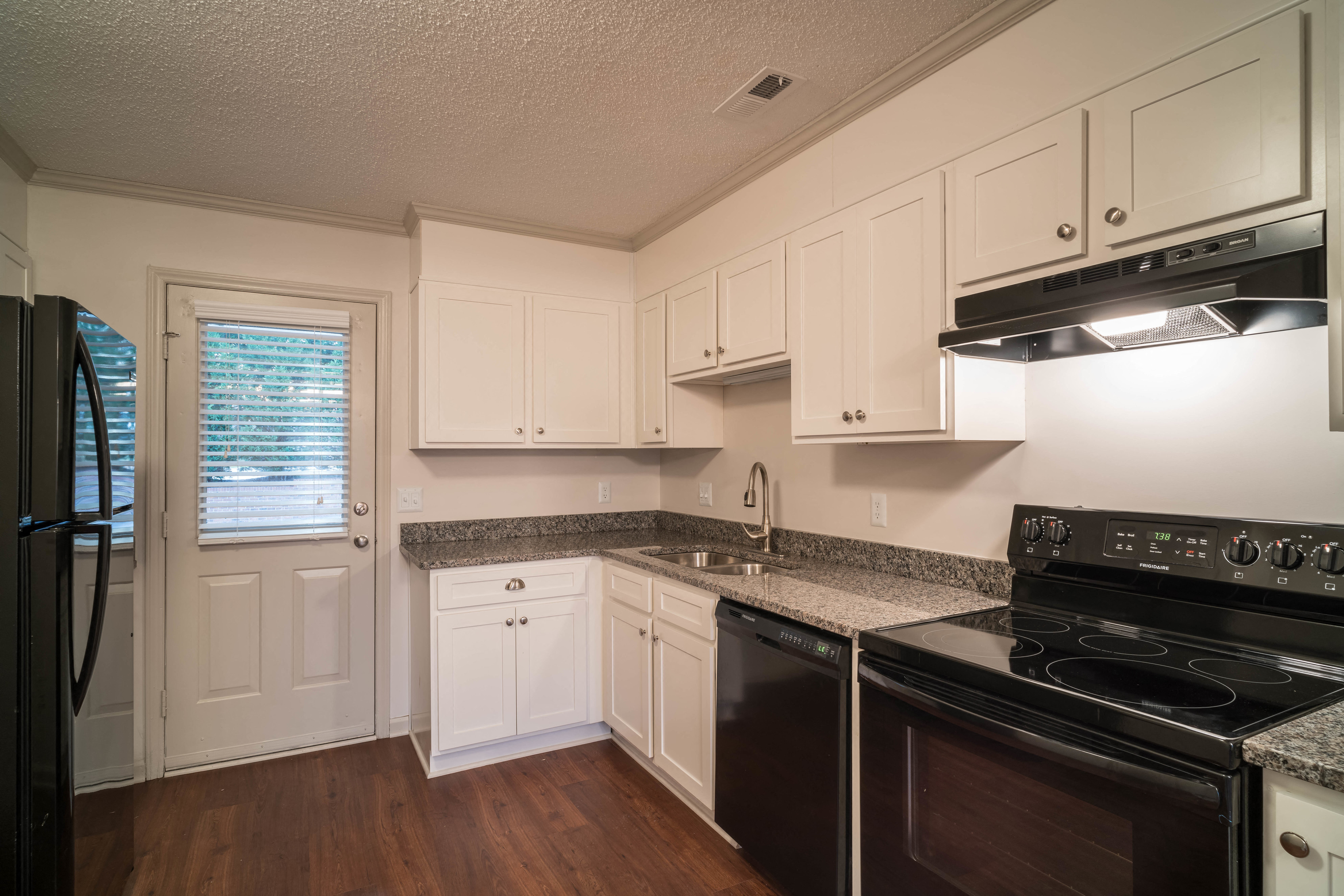 a kitchen with white cabinets and black appliances
