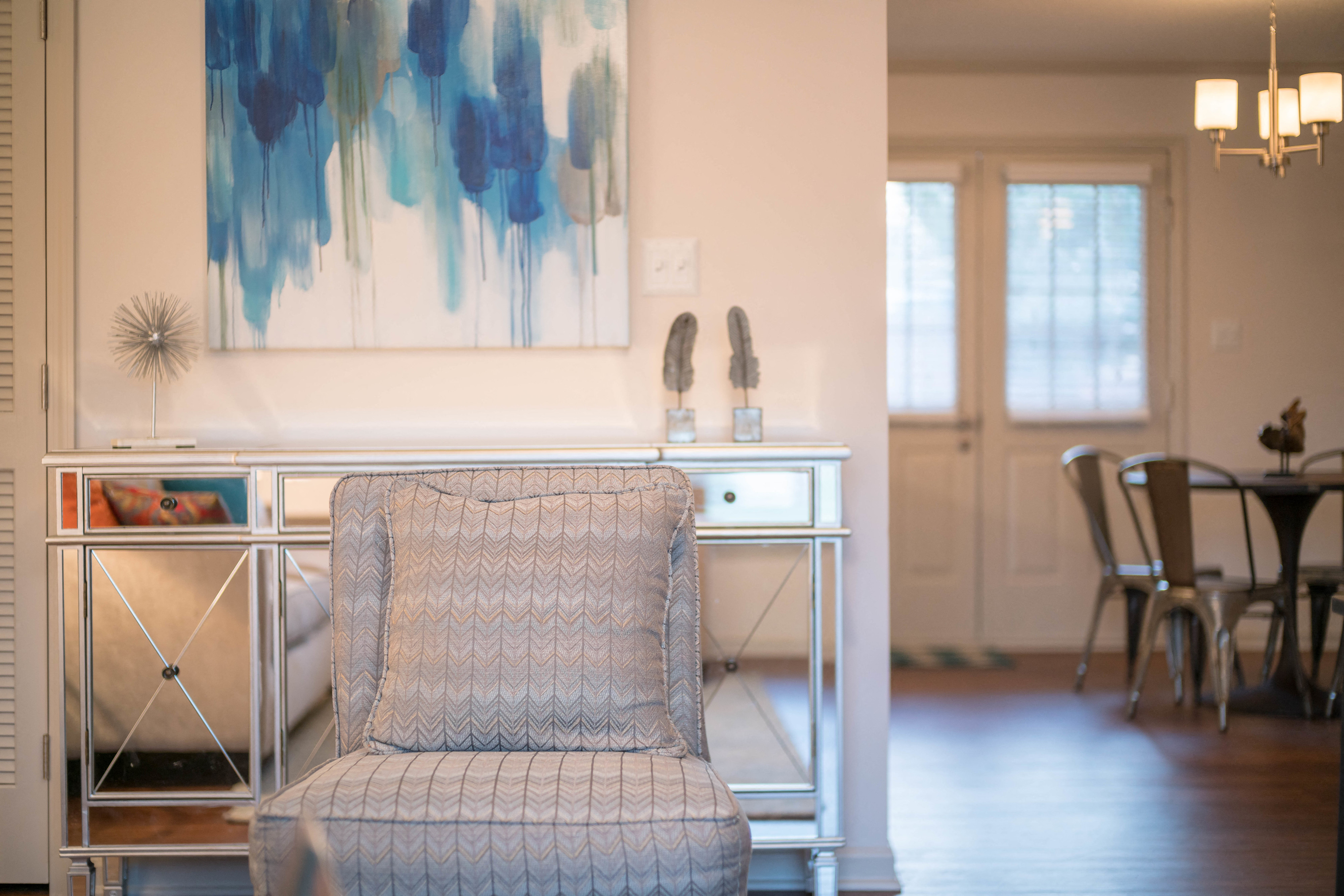 a chair in a living room with a desk and a painting