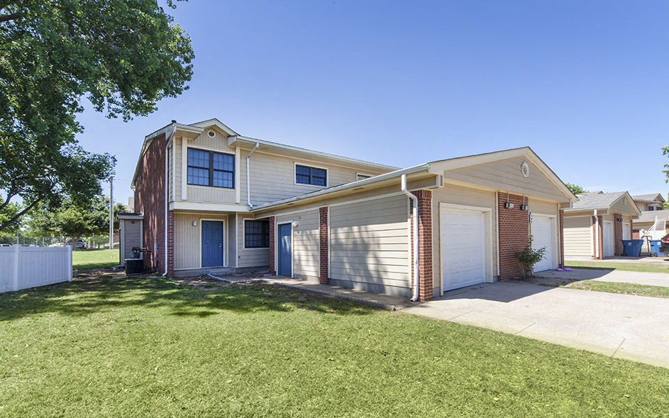 the front of a house with a lawn and a driveway