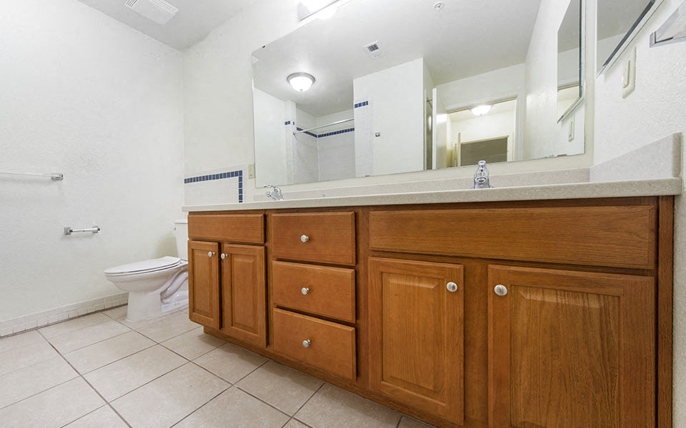 a bathroom with wooden cabinets and a toilet