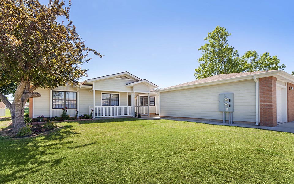a white house with a yard and a tree