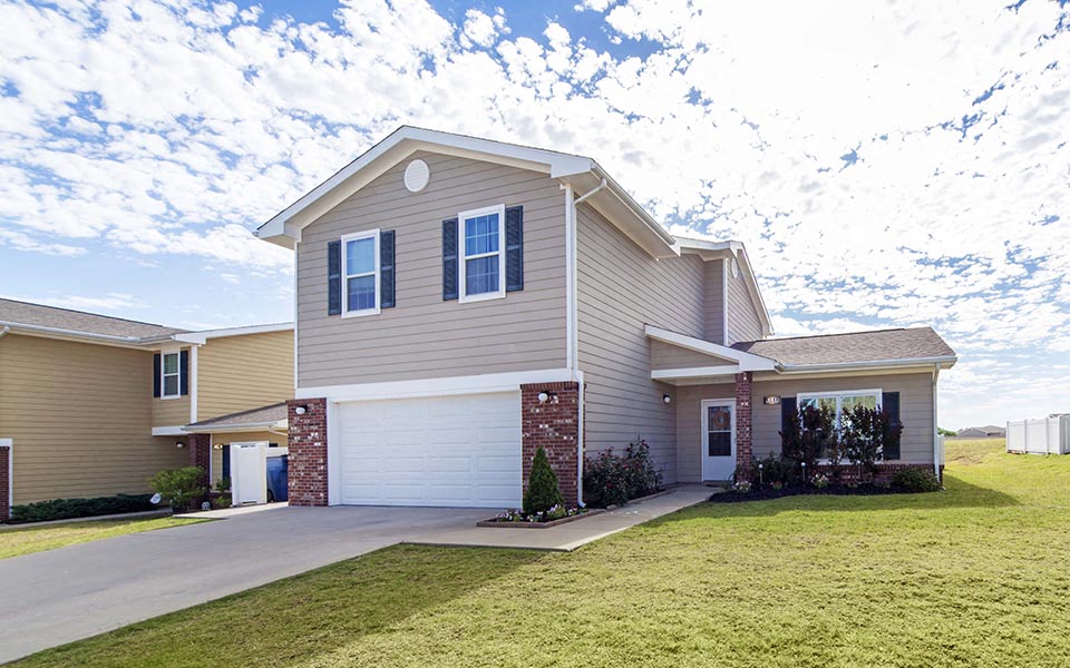 a beige house with a lawn in front of it