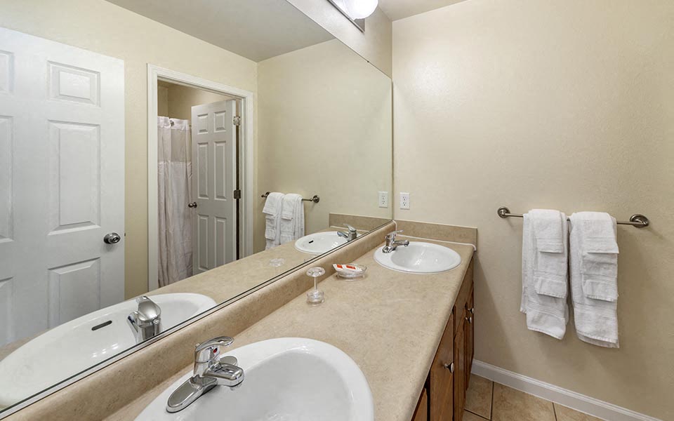 a bathroom with two sinks and a large mirror