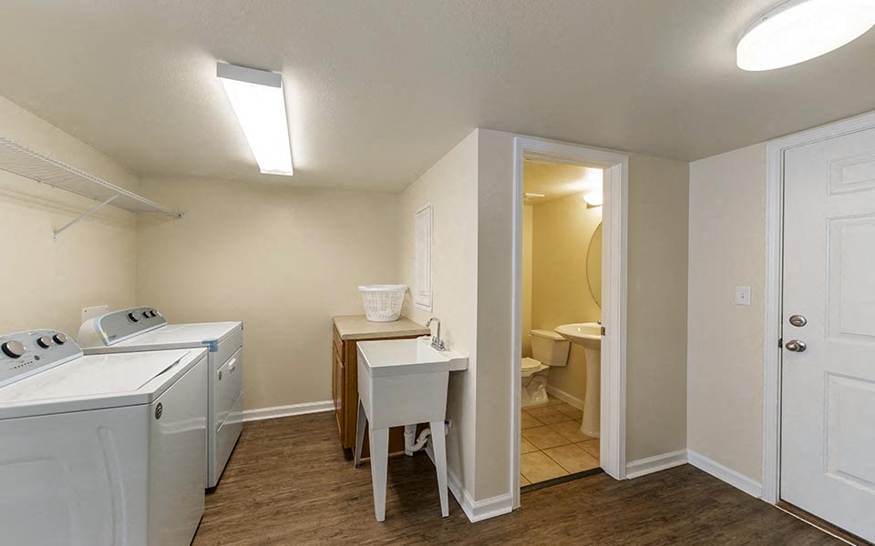 an empty laundry room with a washer and dryer and a sink