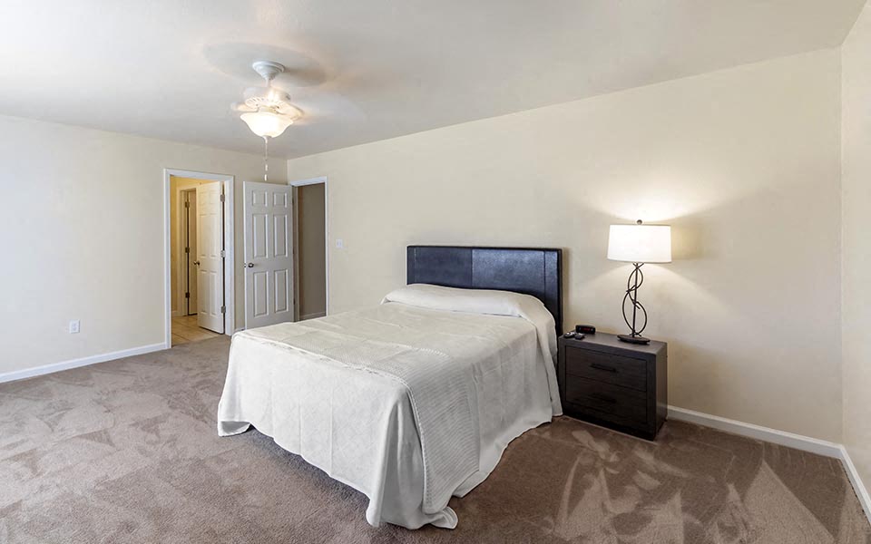 a bedroom with a bed and a lamp