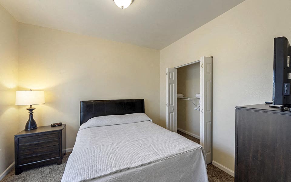 a bedroom with a bed and a tv