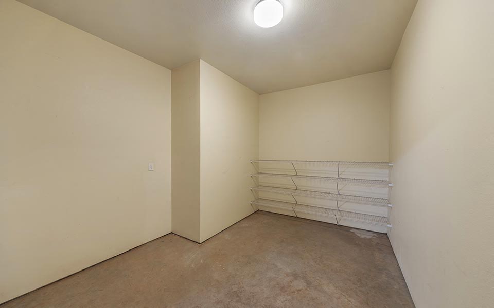 an empty room with white walls and a concrete floor