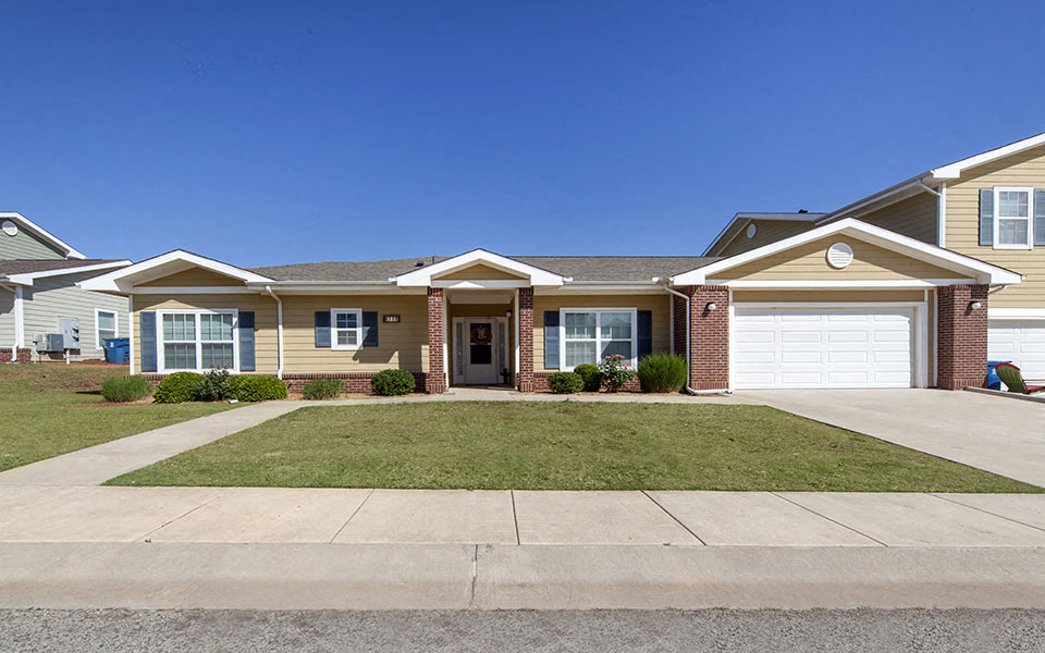 a house with a driveway and lawn in front of it