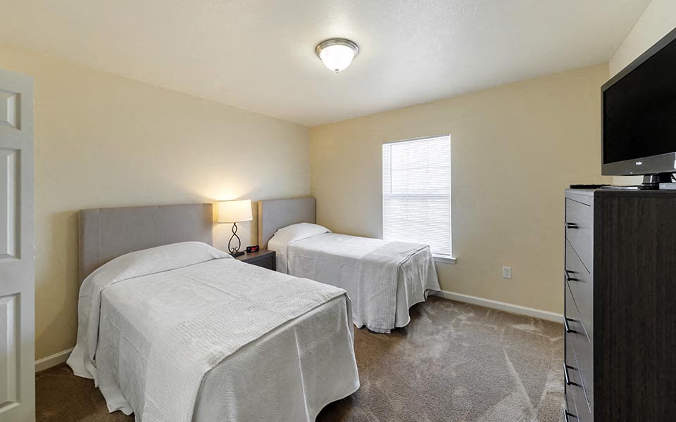 a bedroom with two beds and a television