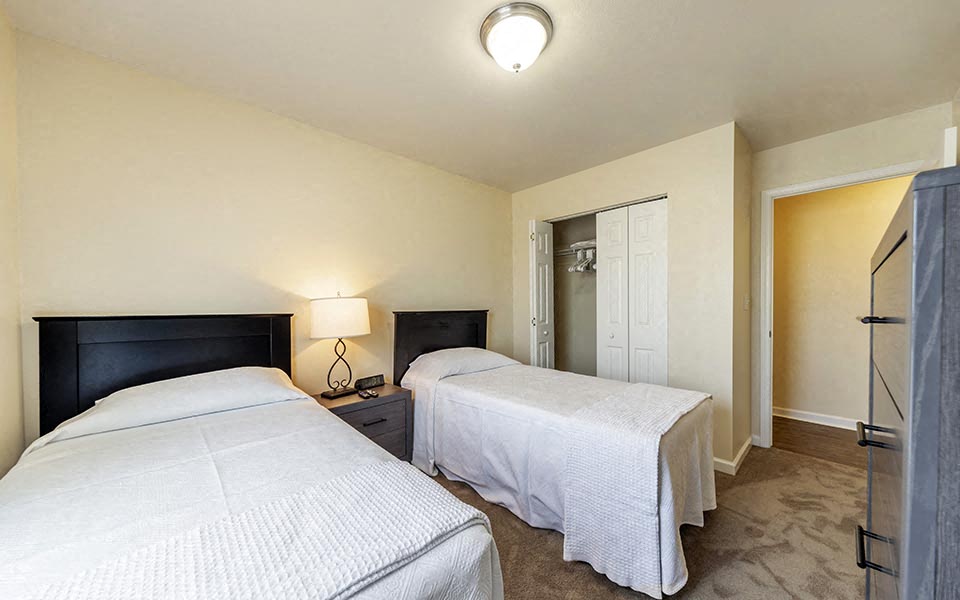 a bedroom with two beds and a closet