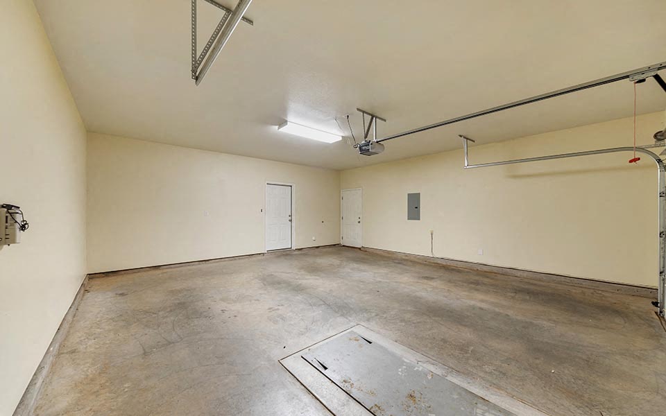 an empty room with a white wall and a garage door