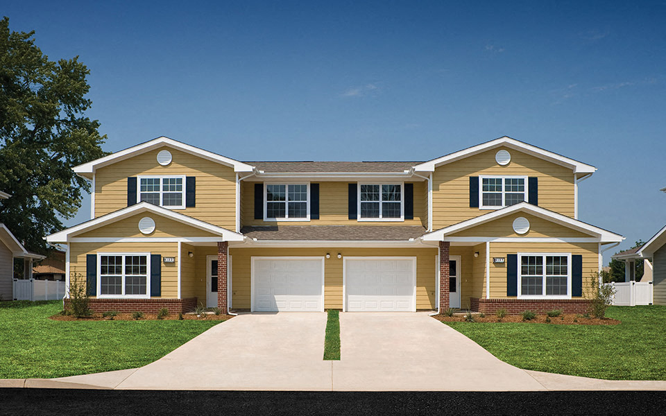a yellow house with a white garage door