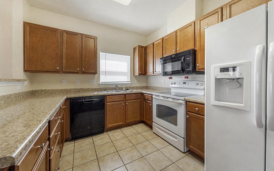 a kitchen with white appliances and wooden cabinets