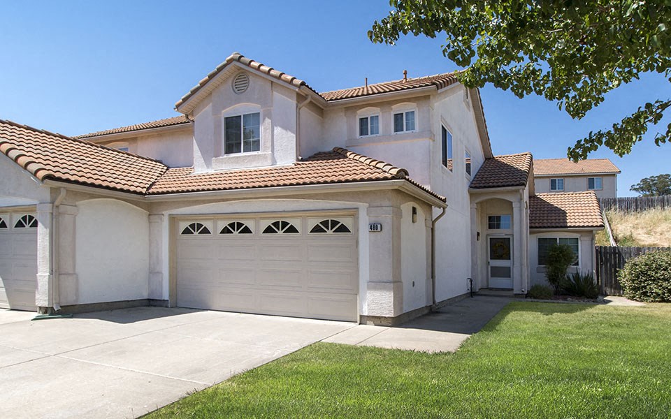 a white house with a garage and a lawn