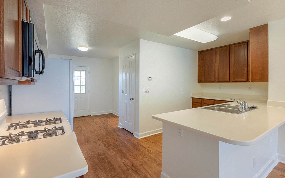 an empty kitchen with a stove and a sink